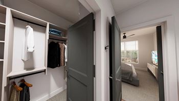 a walk in closet with a door open to a bedroom